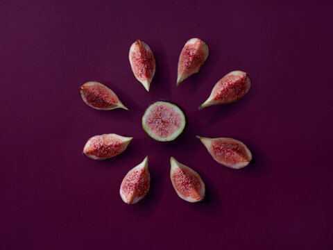 Overhead view of fig slices arranged in a star shape on a purple background