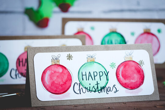 Close-up of homemade watercolour paint Christmas Cards on a table