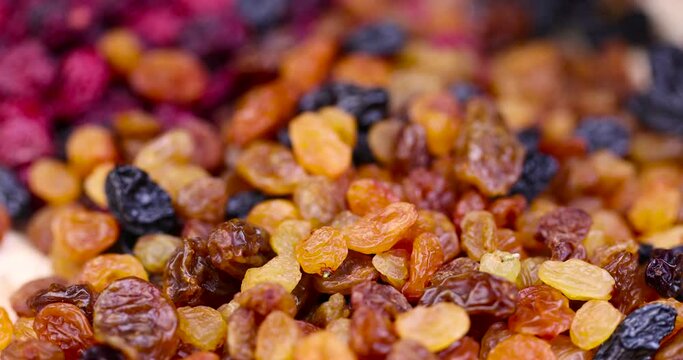 dried cranberries with yellow and black raisins mixed together, a mixture of dried fruits on the table