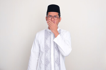 Moslem Asian man showing worry expression with one hand covering his mouth