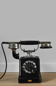 Vintage telephone near light wall
