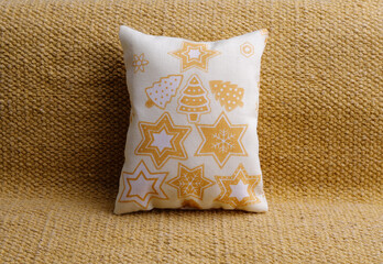 Yellow holiday pillow with stars on the sofa