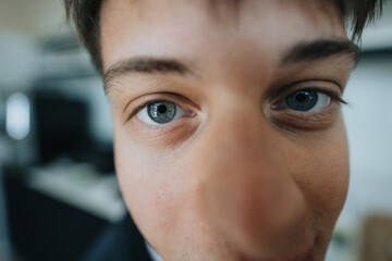 Close up of young male person with blue eyes looking at the camera.