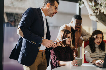 Fototapeta premium Multi generational colleagues collaborating on business expansion, innovation, and profitability in a corporate office.