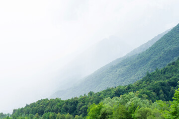 Obraz premium Beautiful landscape of the layered misty hazy Italian Alps mountain range during evening. Alpine summer sunrise. Lombardy, Italy
