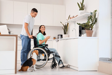 Young woman in wheelchair and her husband with Beagle dog at home