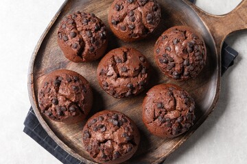 Tasty chocolate muffins on grey table, top view