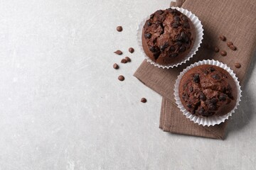 Tasty chocolate muffins on grey table, top view. Space for text