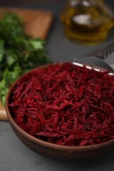 Grated red beet in bowl on table, closeup