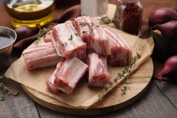 Cut raw pork ribs with thyme on wooden table