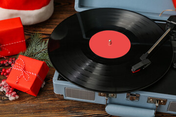 Vintage turntable with vinyl record and Christmas decorations on wooden background