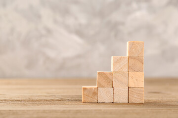Cubes on wooden table against grunge background, closeup