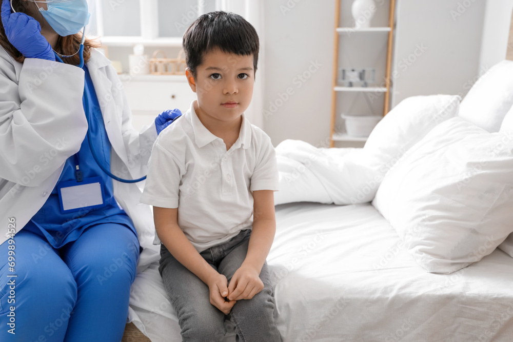 Poster doctor listening lungs of ill little asian boy in bedroom