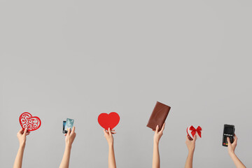 Women with hearts, credit cards, wallet and payment terminal on light background. Valentine's Day celebration