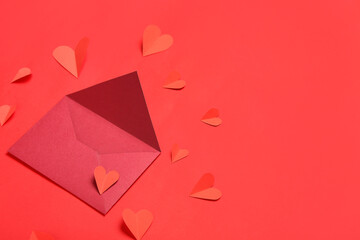 Composition with envelope and paper hearts on red background. Valentine's Day celebration