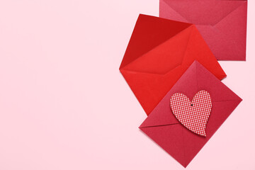 Obraz premium Composition with envelopes and paper heart on pink background. Valentine's Day celebration