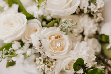 Graceful wedding moment: Wedding Rings with stunning white floral bouquet.