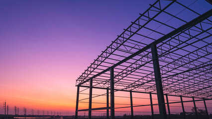 Silhouette metal warehouse building outline structure in construction site with row of electric...