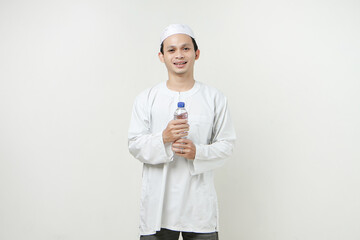 asian muslim man holding a water bottle with smile face on isolated background