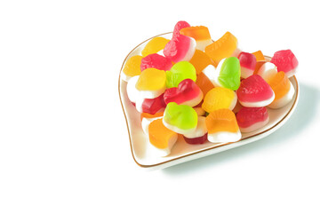 Multi-colored jelly candies on a decorative plate, isolated on a white background.