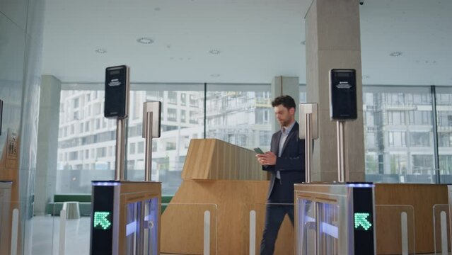 Company worker entering turnstile using face recognition screen in office hall