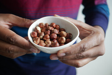holding a hazelnuts bowl closeup 