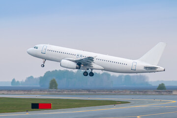 Fototapeta na wymiar Take off of a white passenger aircraft on the runway
