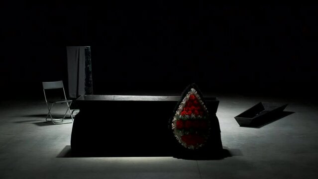 Coffin on stage. Stock footage. Dark scene with empty coffin and funeral belongings. Empty coffin on stage in emotional modern theater production