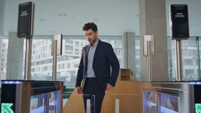Businessman cannot enter turnstile modern company lobby. Manager failed face id