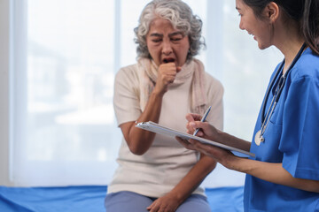 Health check concept, Elderly Asian woman with grey hair, sitting and talking to young Asian nurse...
