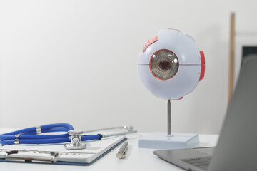 A blue stethoscope, clipboard with medical form, and a pen lie on a white surface, suggesting a clinical setting.