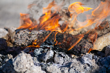 Burning flame on firewood inside the campfire