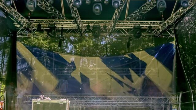 Timelapse of crew setting up stage background for musical event or rock concert