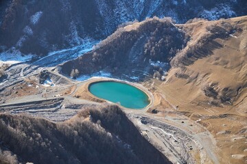 High mountain ranges with snow caps. A small mountain lake. Winter time of the year. Landscape