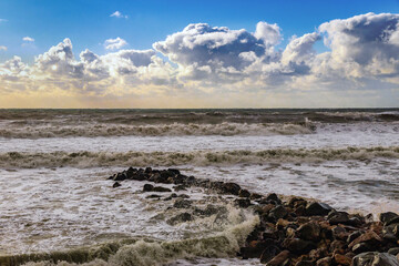 A storm on the Black Sea coast. Large waves crash against the shore under an impressive cloudy sky. A view of the epic stormy seascape. Beautiful sea waves beat against the shore during a storm. 