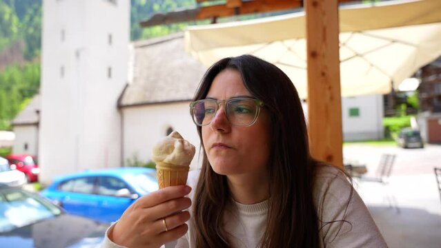 Closeup portrait of woman enjoying eating ice cream in Italian exterior bar