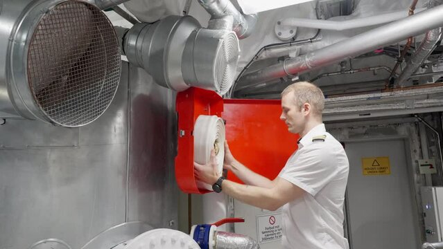Captain inspect fire hose in ships engine room area