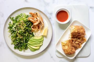 Green salad, avocado with fried toro salmon and omelet with crab. Healthy and balanced menu.