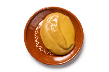 Mustard in a ceramic plate on a white background. Fresh fragrant mustard close-up.
