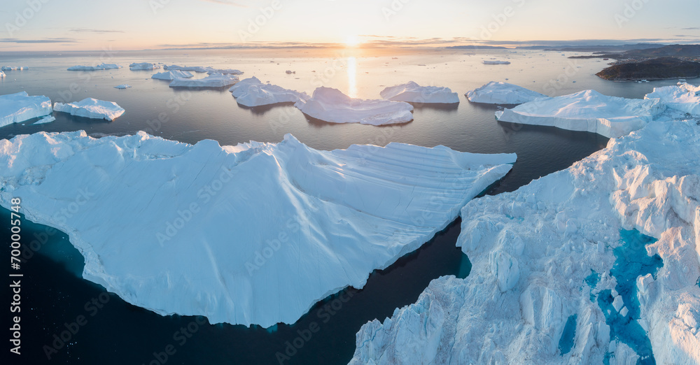 Wall mural Melting icebergs by the coast of Greenland, on a beautiful summer day - Melting of a iceberg and pouring water into the sea. Global warming
Arctic nature landscape, Summer day