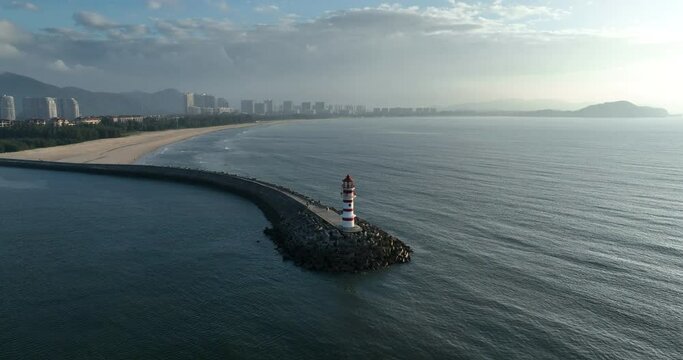 Aerial footage of red and white striped lighthouse on seaside  
