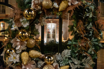 Christmas and New Year street decoration, round Christmas wreath hanging on metal gates, illuminated glass door at night, Epernay, Champagne, France