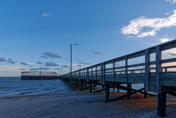 The setting suns Orange light falling on the sand beneath the Pier at Palacios on the Gulf Coast of...