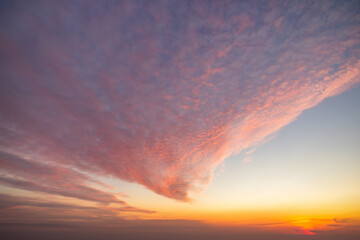 Fototapeta premium A beautiful sky tinted by the sun leaving vibrant shades of gold, pink, blue and multicolored. Clouds in the twilight evening and morning sky. Image of a cloudy sky in the evening and during the day. 