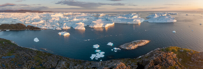 Melting icebergs by the coast of Greenland, on a beautiful summer day - Melting of a iceberg and...