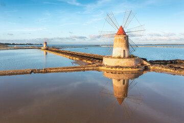 Sunset at Windmills in the salt evoporation pond in Marsala, Sicily island, Italy
Trapani salt flats and old windmill in Sicily.
View in beautifull sunny day. - obrazy, fototapety, plakaty