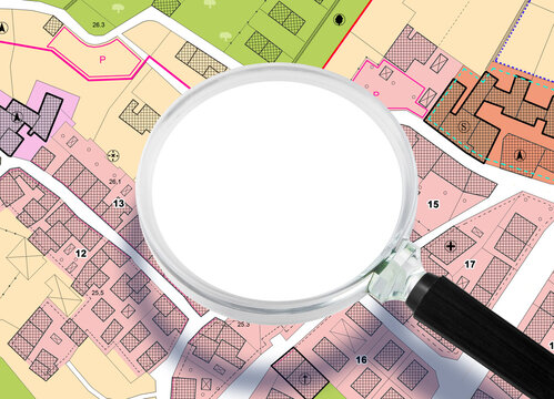 Imaginary General Urban Plan with indications of urban destinations, buildings, roads, buildable areas and land plot - Concept with copy space seen through a magnifying glass