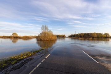 The road is flooded with water, flooding in the countryside.