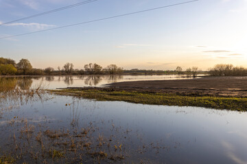 A plowed field is flooded with water, a spring rural landscape after a flood, a river flood.