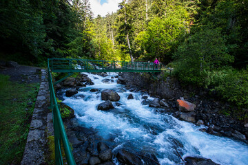 Summer and young girl in Uelhs Deth Joeu waterfall, Val D Aran, Spain